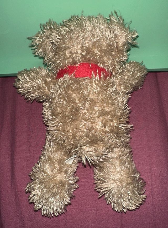 Osito de peluche marrón con bufanda roja
