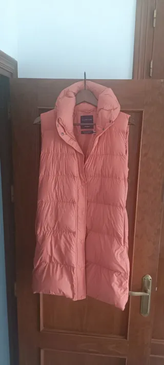 Chaquetón sin mangas de plumas naranja.
