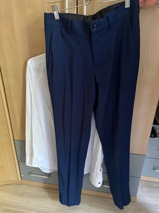 Traje de hombre azul con corbata roja y camisa.