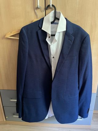 Traje de hombre azul con corbata roja y camisa.