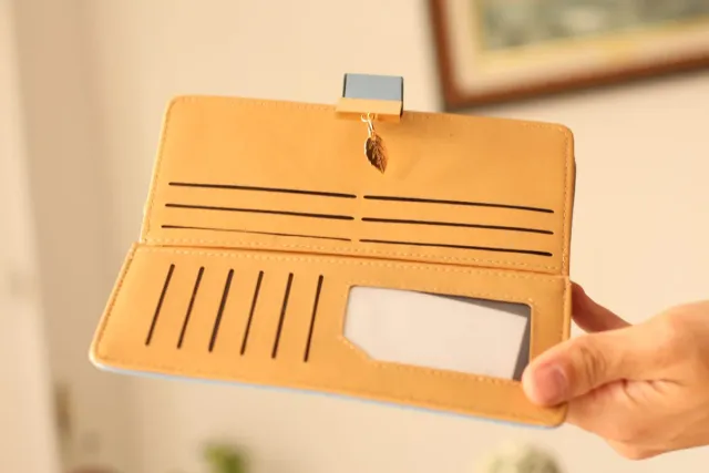 Billetera azul con diseño de hojas doradas.