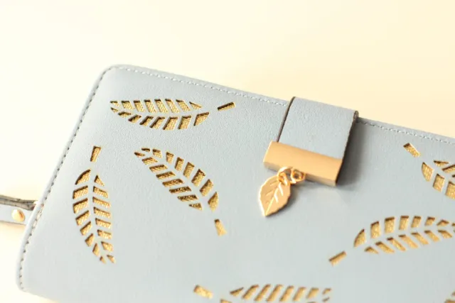 Billetera azul con diseño de hojas doradas.