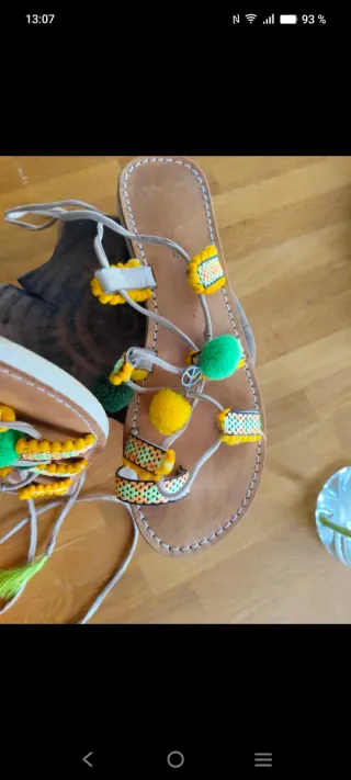 Sandalias planas con tiras y pompones