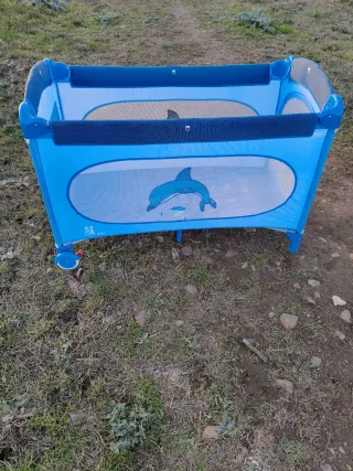 Cuna de viaje azul con diseño de delfín