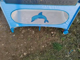 Cuna de viaje azul con diseño de delfín