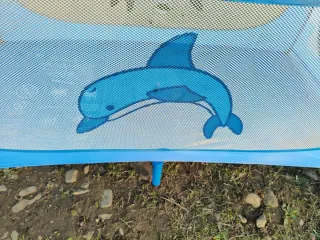 Cuna de viaje azul con diseño de delfín