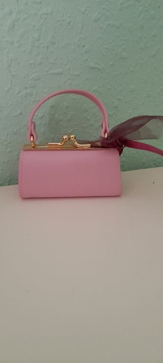 Monedero rosa con asa y cierre dorado