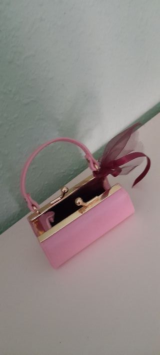 Monedero rosa con asa y cierre dorado