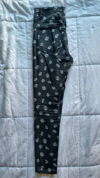 Pantalones negros con estampado de margaritas