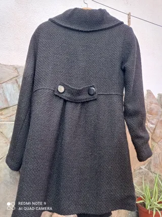 Elegante abrigo negro con botones y con flor