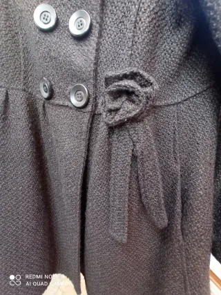 Elegante abrigo negro con botones y con flor