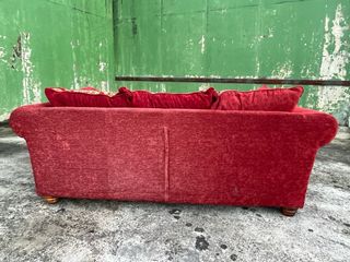 Sofá de tela rojo con cojines decorativos