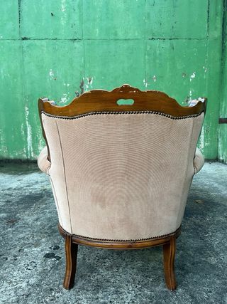 Sillón tapizado beige con detalles madera