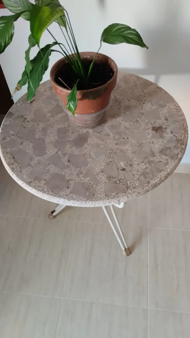 Mesa redonda de mármol y metal.