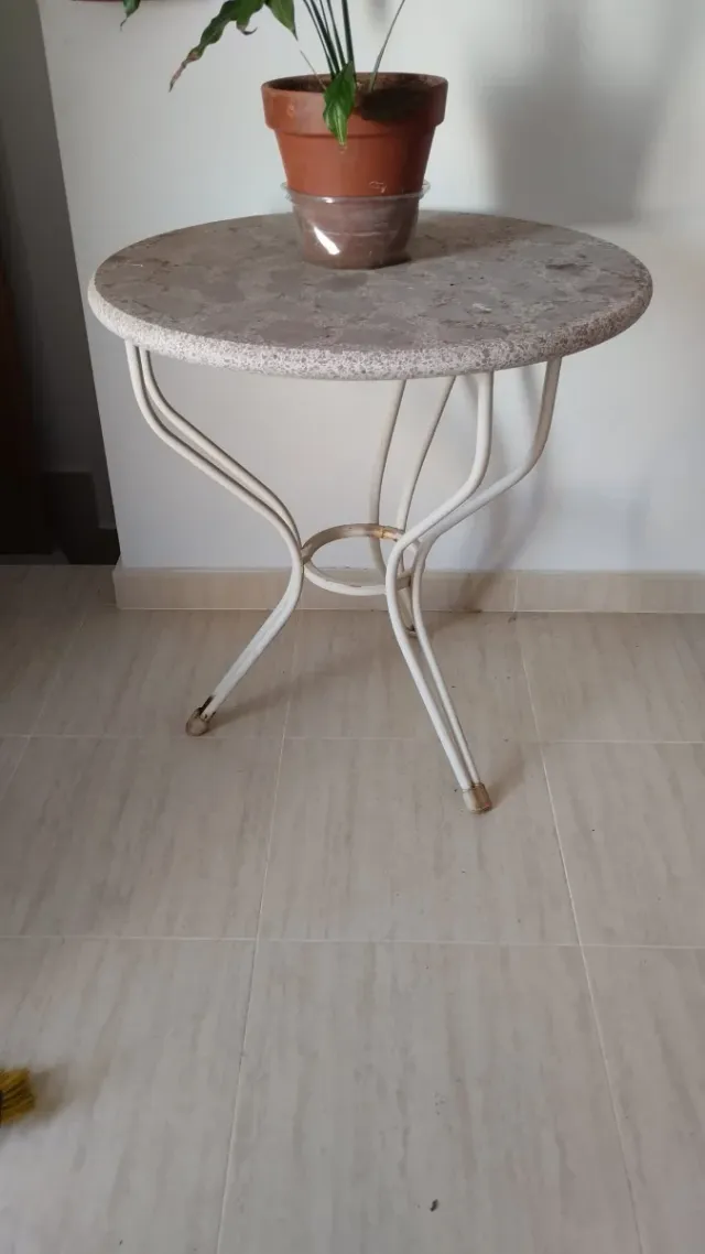 Mesa redonda de mármol y metal.