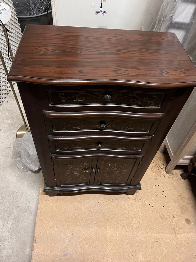 Cômoda de madeira escura com gavetas