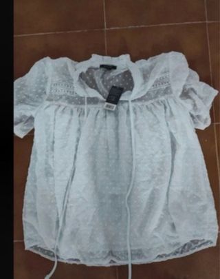 Blusa blanca con volantes y lazada