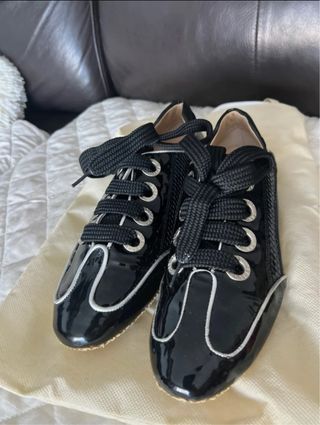 Zapatos planos negros con cordones de charol .