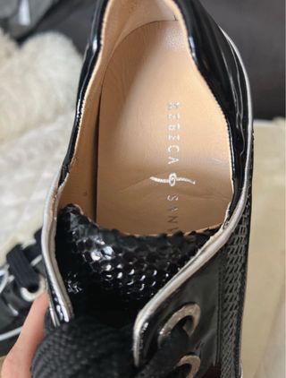 Zapatos planos negros con cordones de charol .