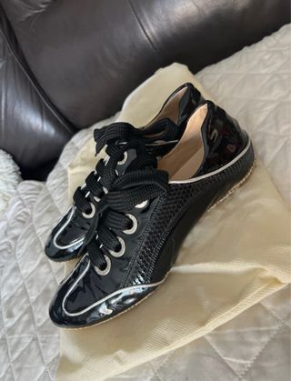 Zapatos planos negros con cordones de charol .