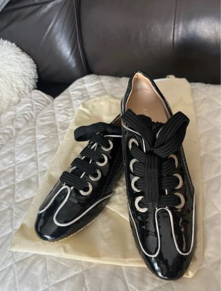 Zapatos planos negros con cordones de charol .