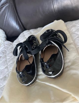 Zapatos planos negros con cordones de charol .