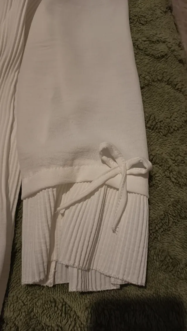 Blusa blanca plisada con lazos en manga