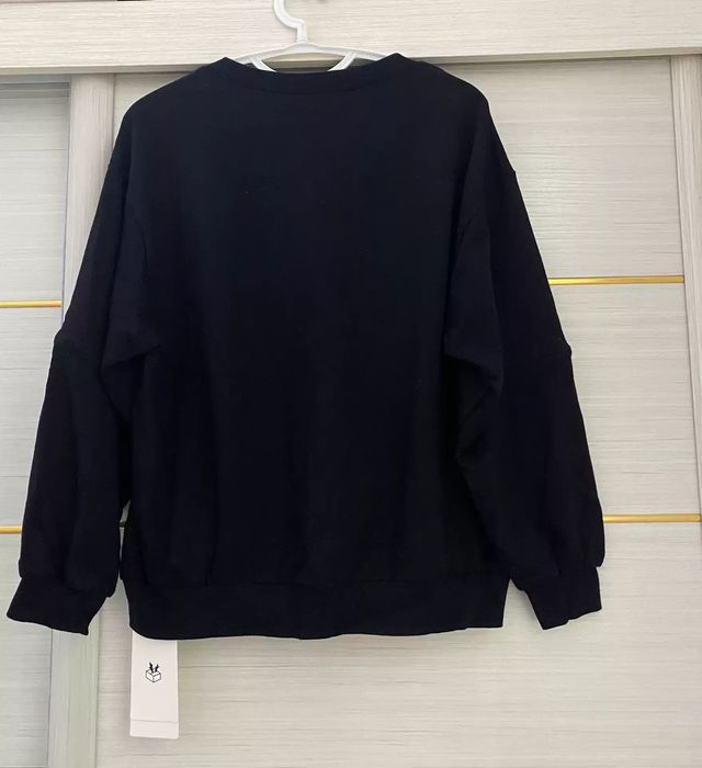 Maglia nera con scritte e bottoni