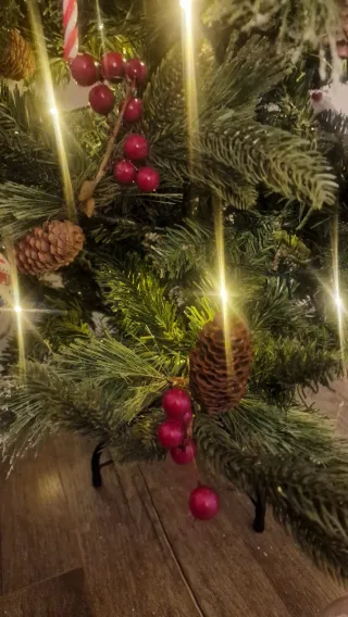 Árbol de Navidad con piñas y frutos rojos.