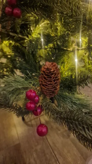Árbol de Navidad con piñas y frutos rojos.