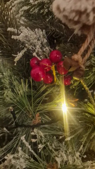 Árbol de Navidad con piñas y frutos rojos.