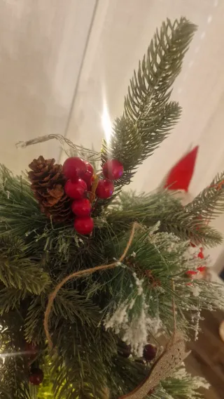 Árbol de Navidad con piñas y frutos rojos.
