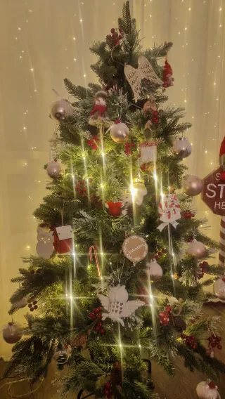 Árbol de Navidad con piñas y frutos rojos.