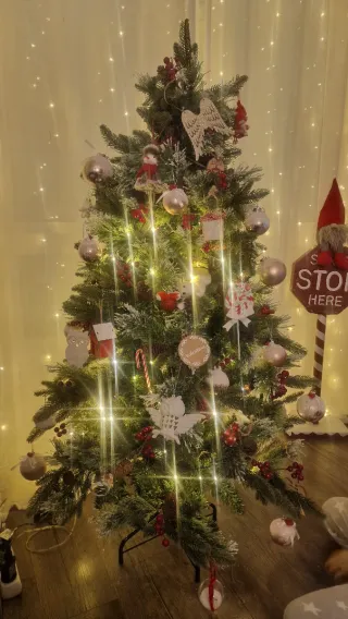 Árbol de Navidad con piñas y frutos rojos.