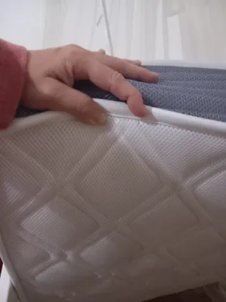 Cuna de bebé blanca con mosquitera