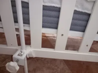 Cuna de bebé blanca con mosquitera