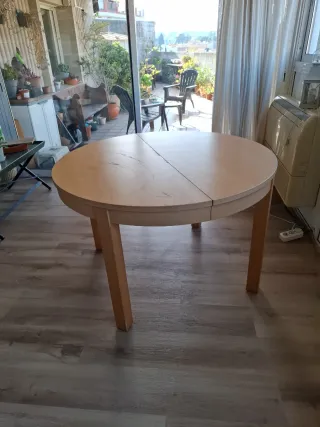 Mesa redonda extensible de madera.