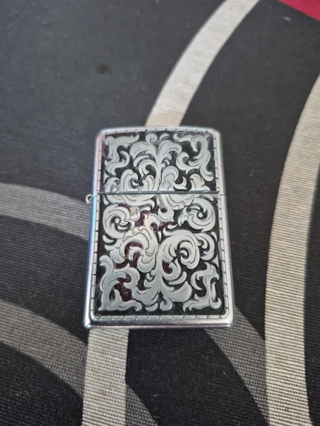 Accendino Zippo con design inciso e finitura argentata