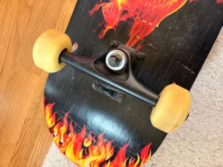 Monopatín con diseño de calavera y llamas.