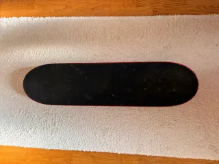 Monopatín con diseño de calavera y llamas.