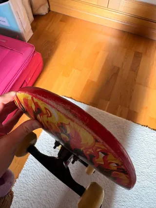 Monopatín con diseño de calavera y llamas.