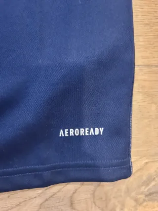 Polo Adidas azul con rayas blancas