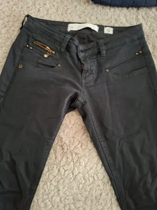 Pantalones negros con cremallera y tachuelas