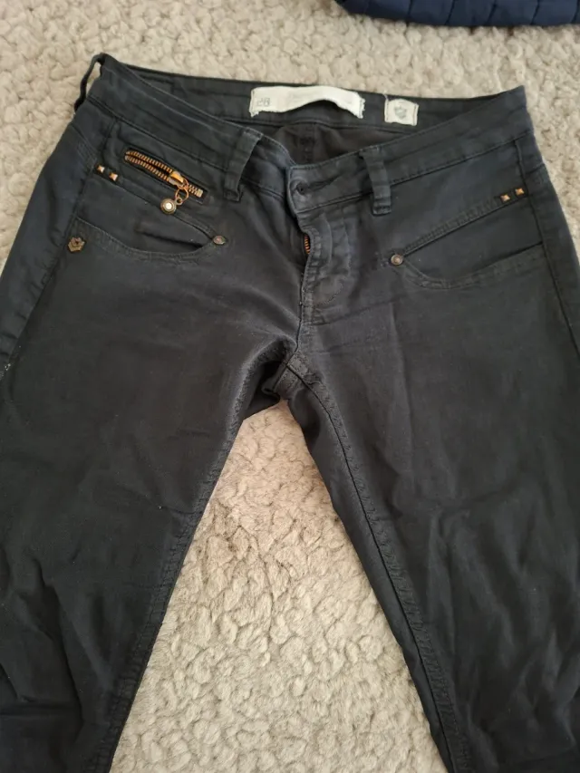 Pantalones negros con cremallera y tachuelas