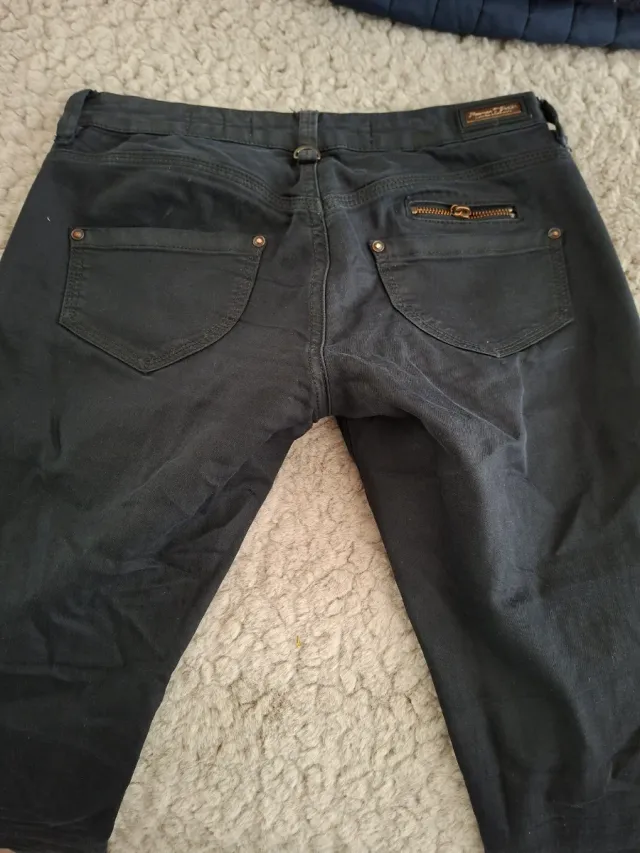 Pantalones negros con cremallera y tachuelas