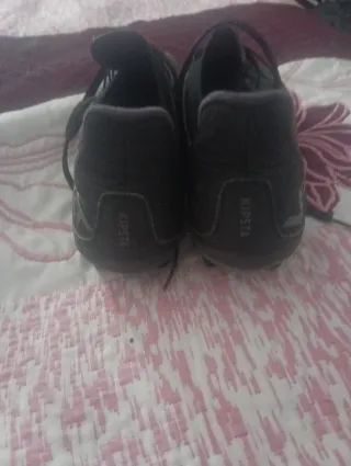 Botas de fútbol negras y doradas