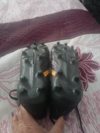 Botas de fútbol negras y doradas