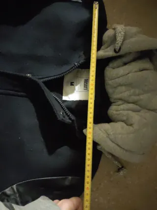 Cazadora negra con capucha de niño. Unos 14 años