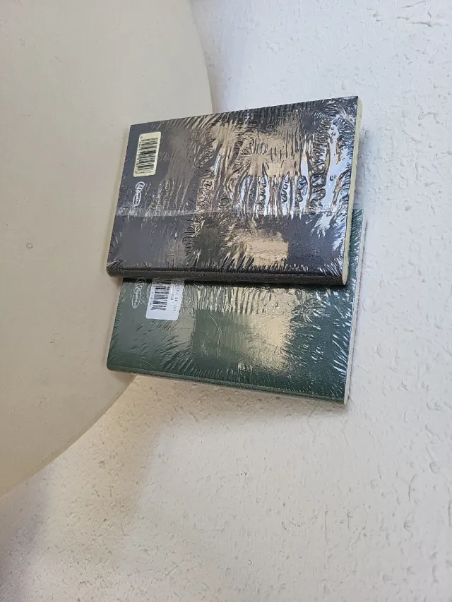 Libretas verde y negra de Miquelrius. Tapa blanda.