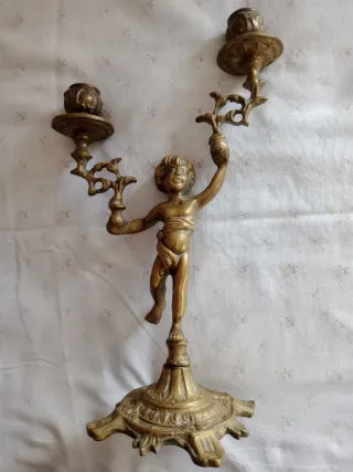Candelabro in metallo dorato con putto